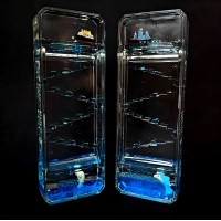 This stress-relieving hourglass features a colorful glitter gel inside, a floating boat, and a dolphin. Dimensions: 16 cm high, 5.5 cm wide.