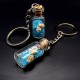 Souvenir keychain glass bottle inside colored granules luminous accumulator and natural shell