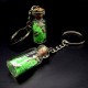 Souvenir keychain glass bottle inside colored granules luminous accumulator and natural shell